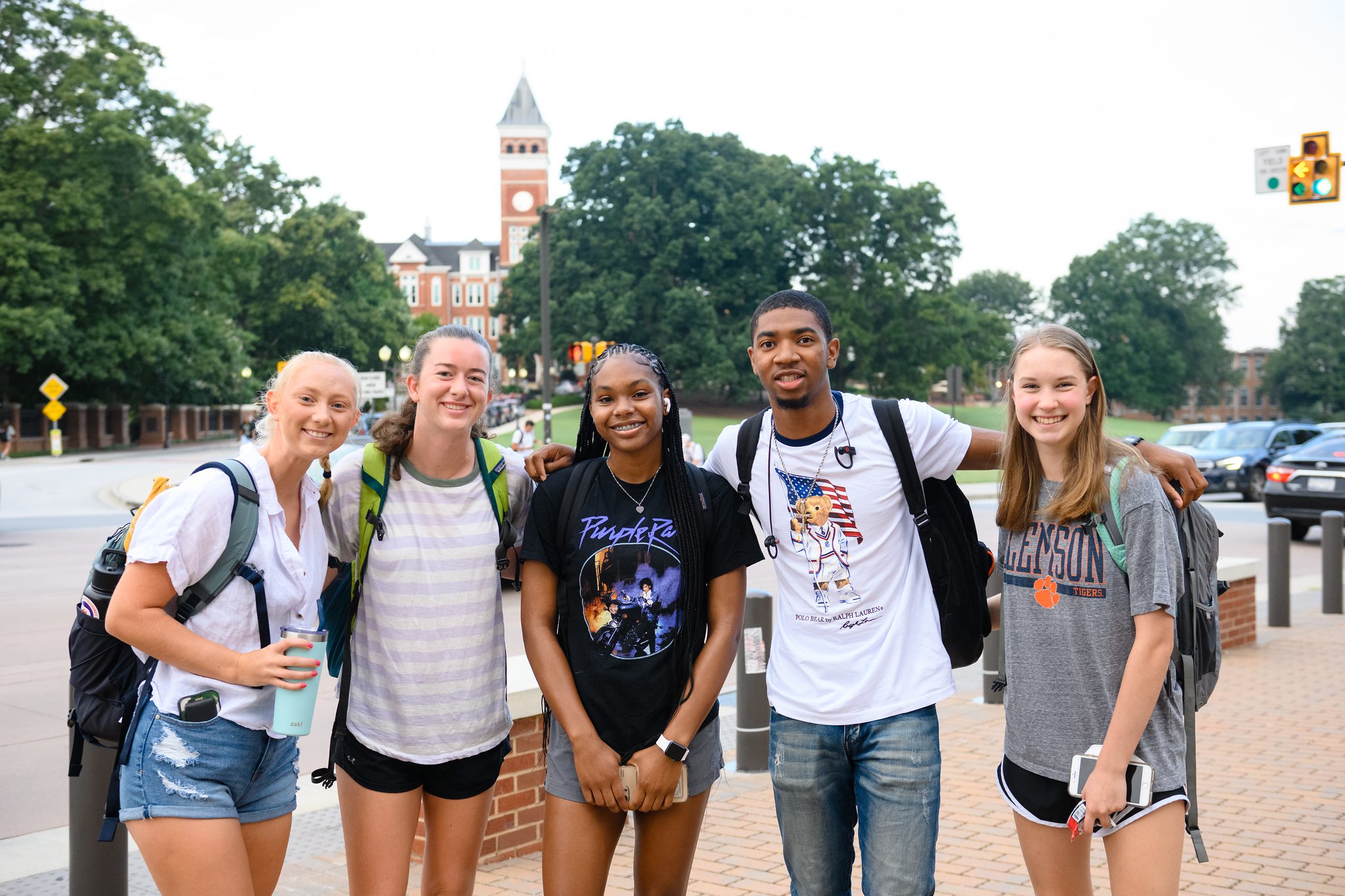 A group of four female students and one male student pose on campus during the first day of classes.
