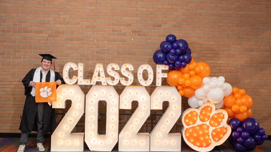 A graduating member of the Class of 2022 takes part in his senior photo at the Alumni Center on Clemson's campus