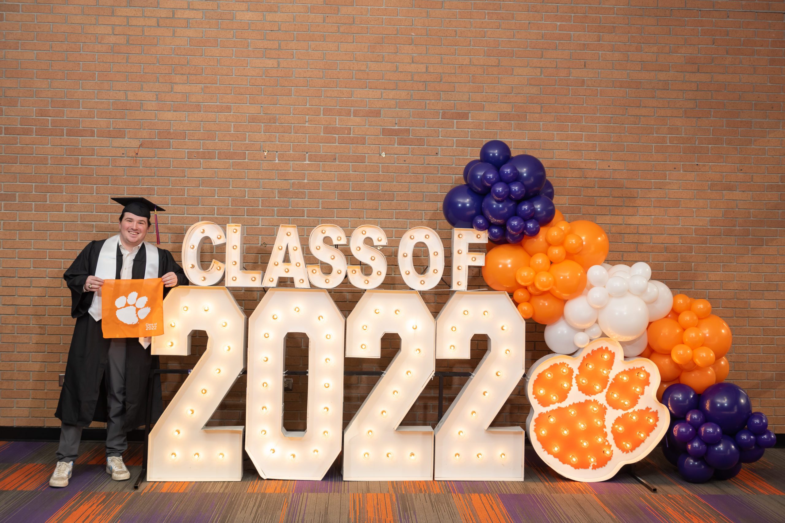 A graduating member of the Class of 2022 takes part in his senior photo at the Alumni Center on Clemson's campus
