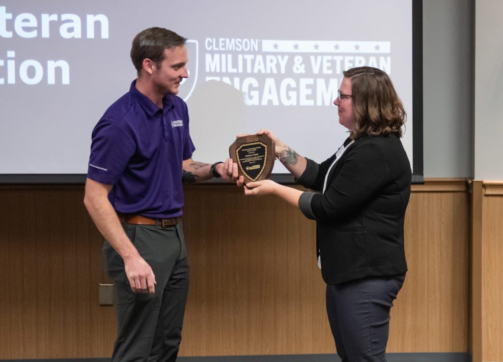 Jackson Grant, left, accepts the Outstanding Student Veteran Award from Emily DaBruzzi on Dec. 20, 2022