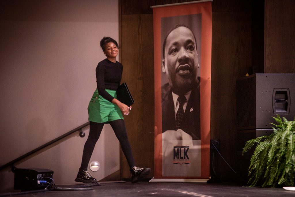 Yolanda King walks past a poster image of her grandfather, Martin Luther King Jr., as she takes the stage.