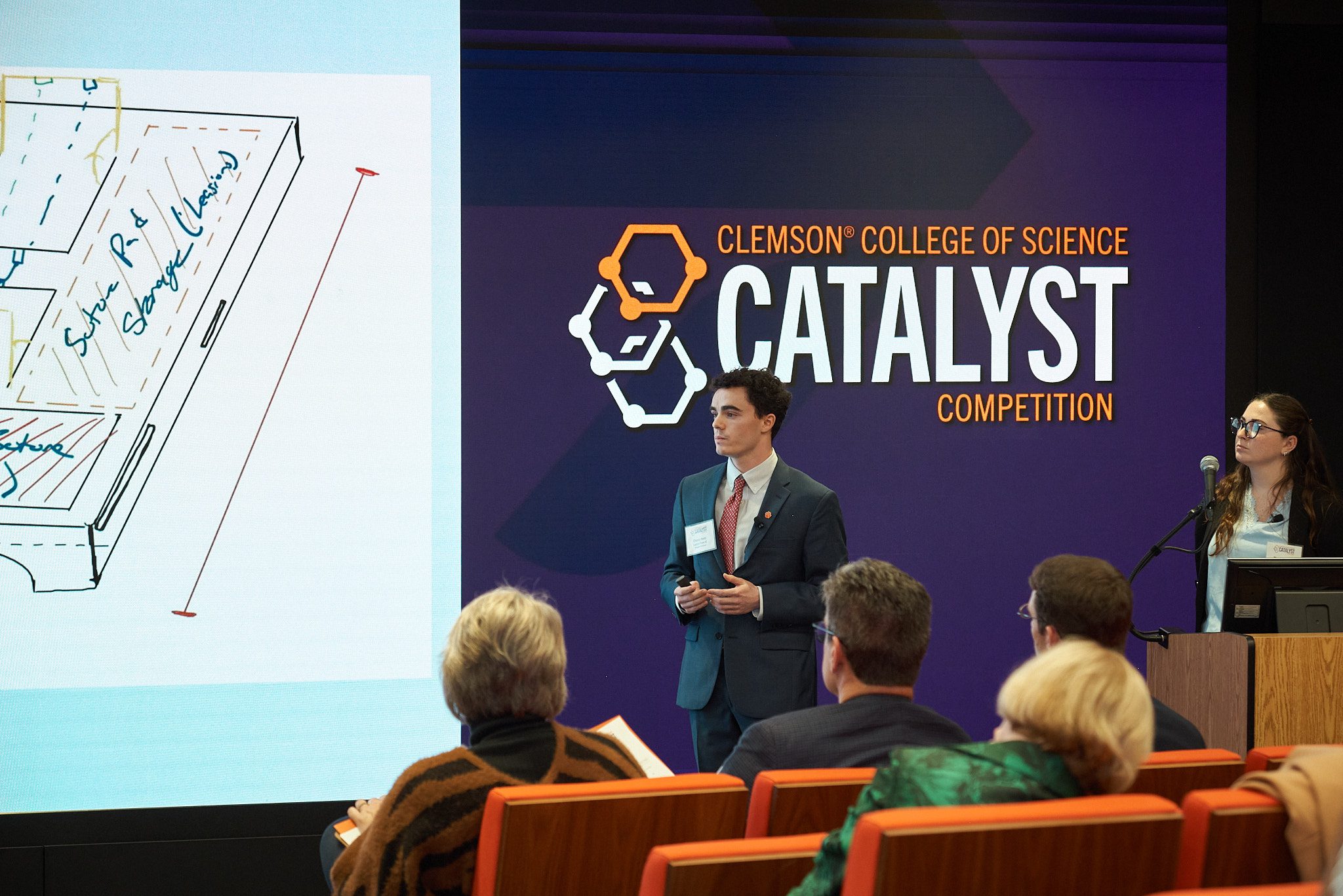 a man in a suit presents during the College of Science's Catalyst Competition.
