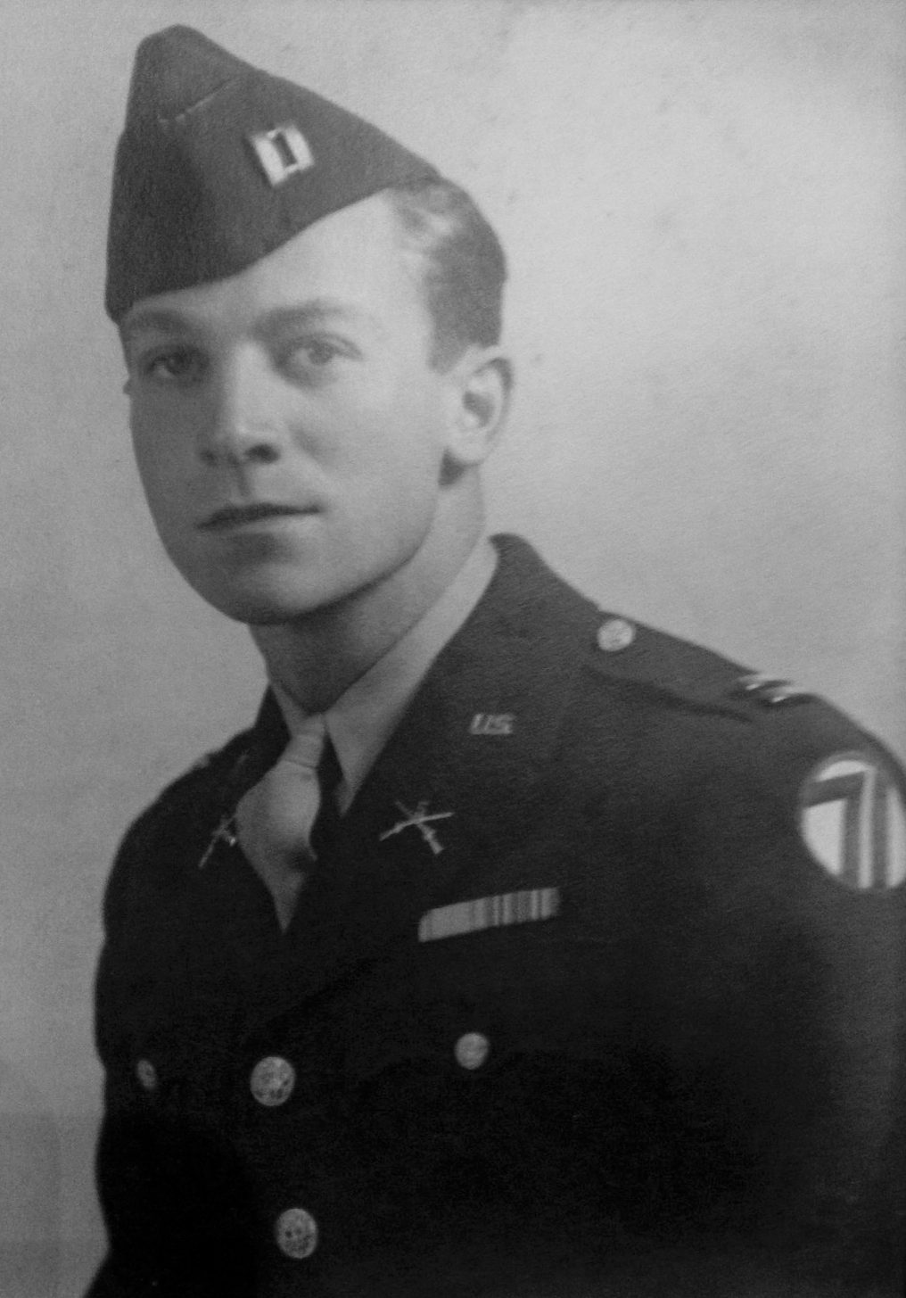A formal black and white historical photo of a man in Army dress uniform