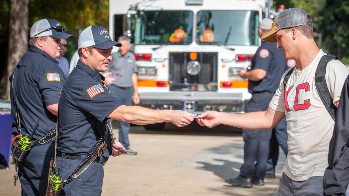 Members of the Clemson Fire Department hand out materials to Clemson students on campus.
