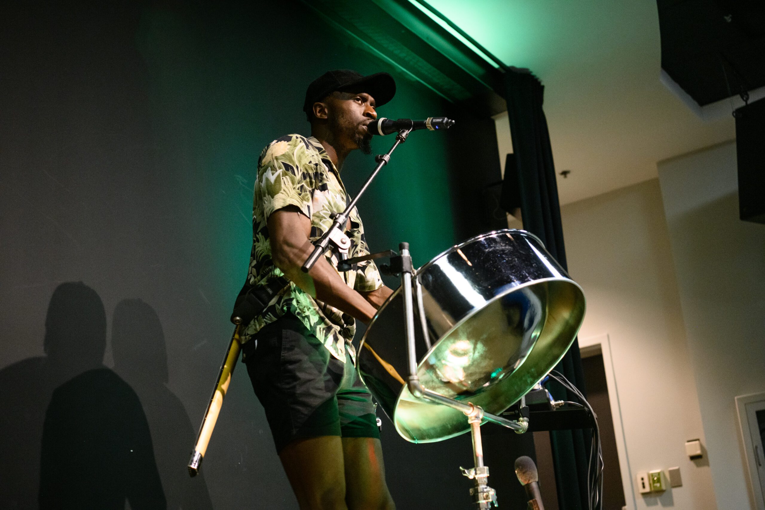 A steel drum player is on a stage performing.