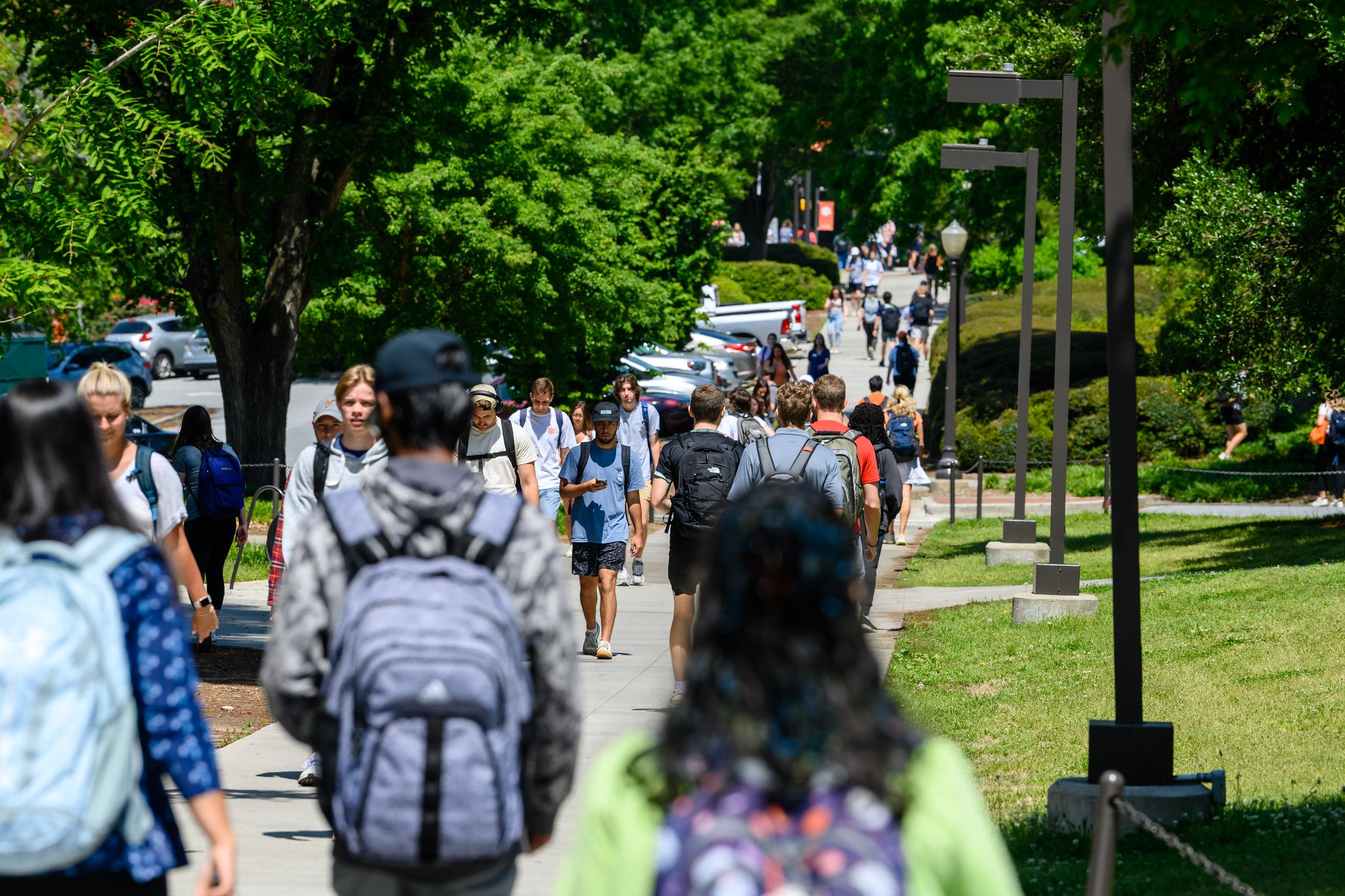 A diverse group of students walking outdoors on campus on a spring day. Photo for 2023 President's List.