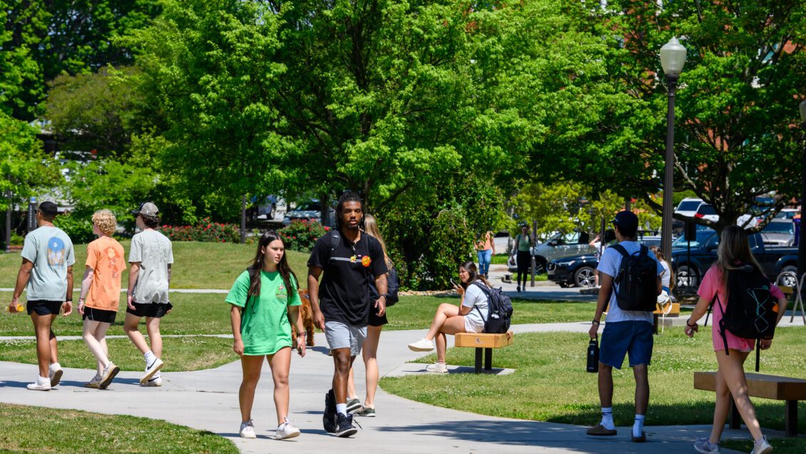 Diverse body of students walking campus grounds on a spring day. Photo for Spring 2023 Dean's List.