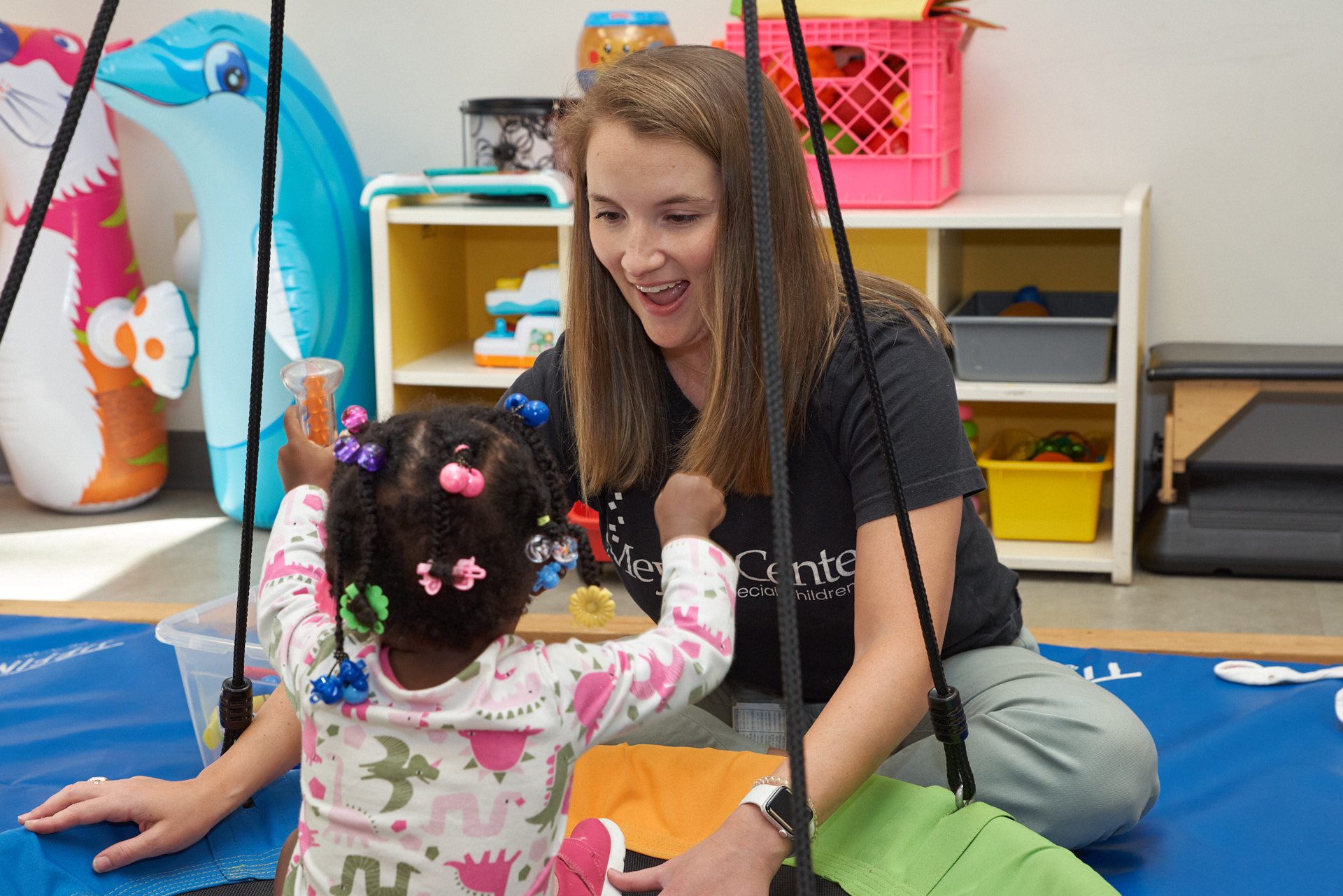 Woman (Elizabeth Timmons) works with a child at the Meyer Center for Special Children
