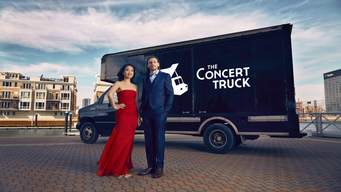 Susan Zhang and Nick Luby stand in front of The Concert Truck on a city street.