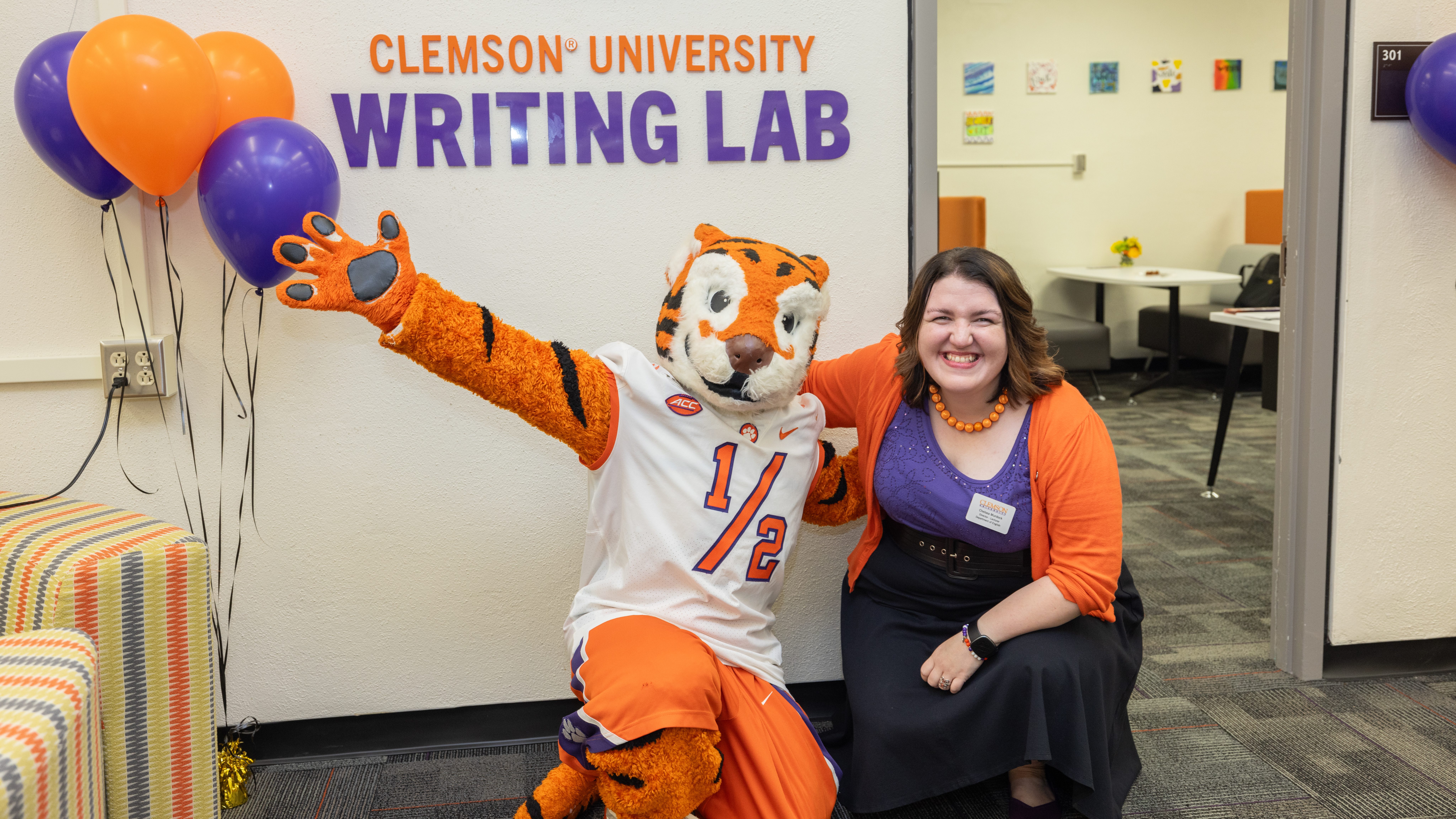 The Tiger cub and Writing Lab director Chelsea Murdock smile in front of the entrance to the Writing Lab