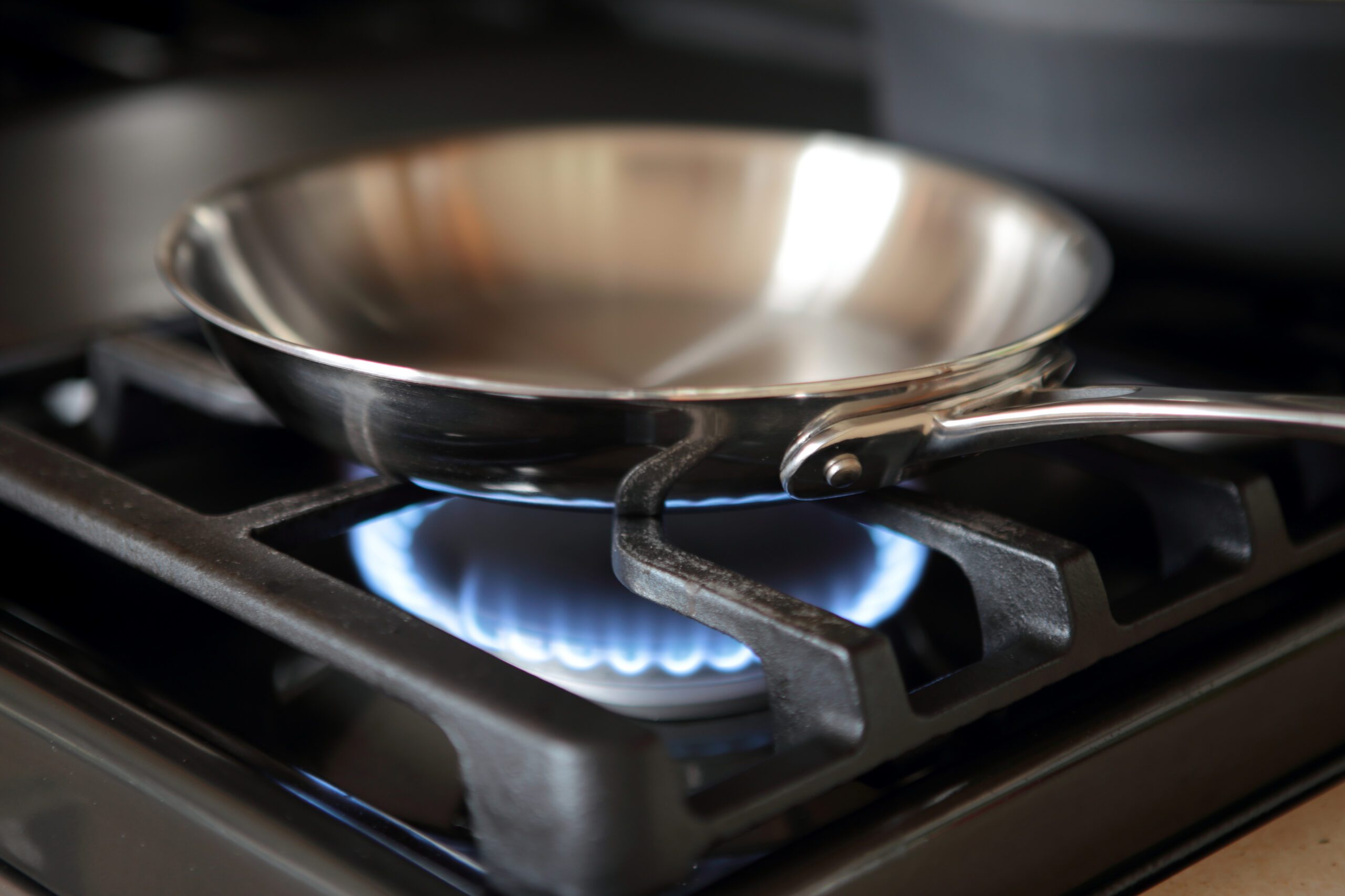 A frying pan sitting on a gas stove top.