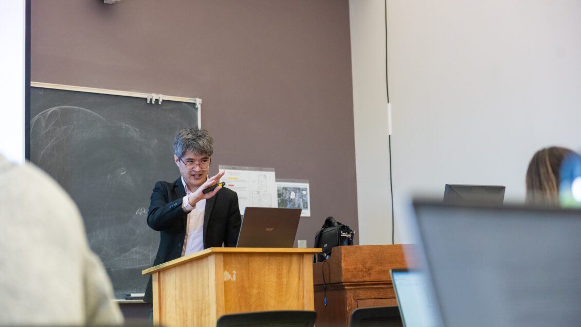 Quinn Hiroshi Gibson lectures inside a Hardin Hall classroom.