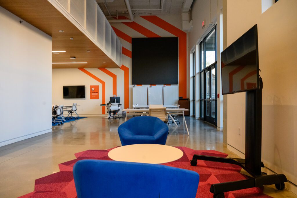 A meeting space in the foyer of the Brook T. Smith Launchpad with moving screens, tables and chairs.