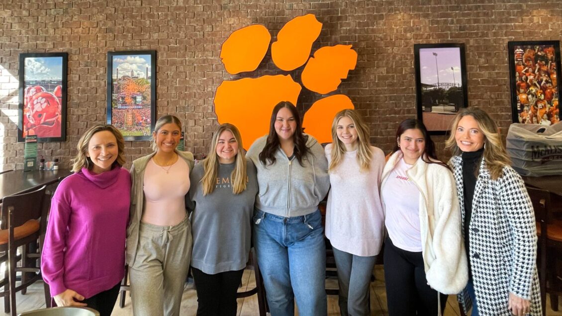 Clemson University students pose for a picture in front of the iconic Tiger Paw.
