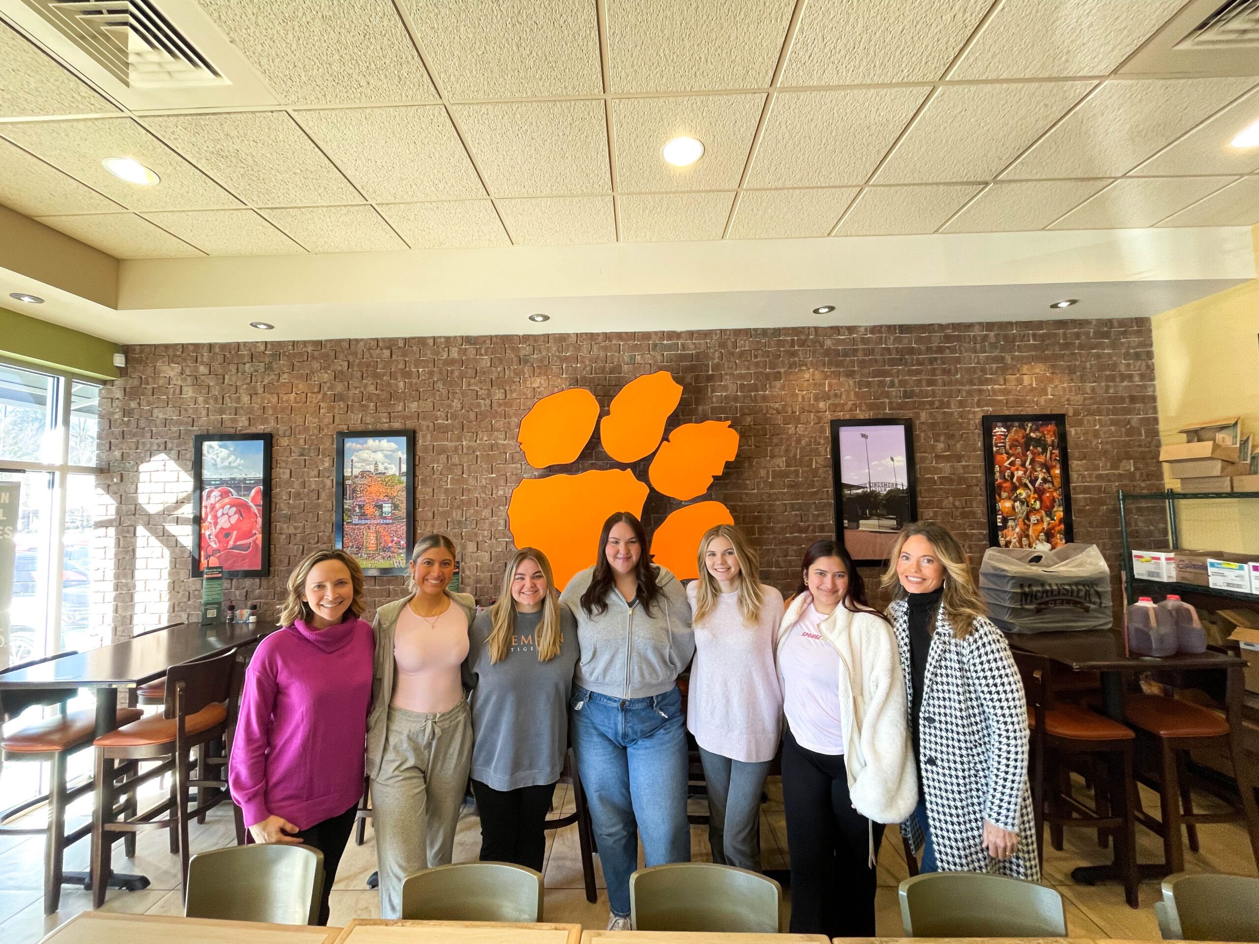 Clemson University students pose for a picture in front of the iconic Tiger Paw.