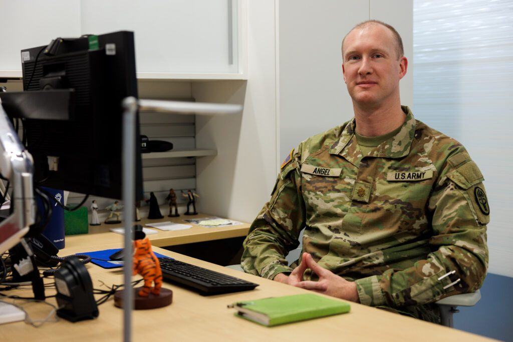 Man in an Army uniform sits at a desk