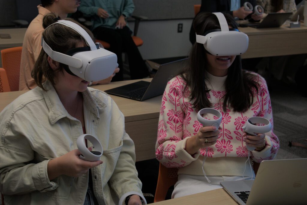 Two Clemson students using VR headsets in class.