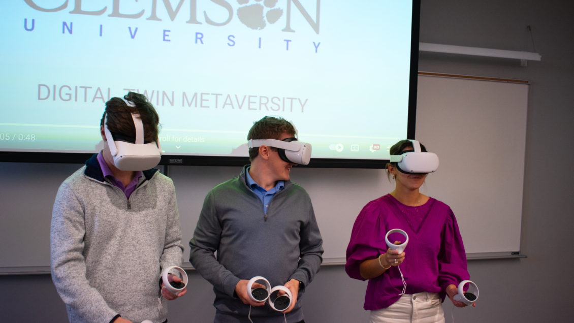 A group of 3 Clemson students using VR headsets in a class.