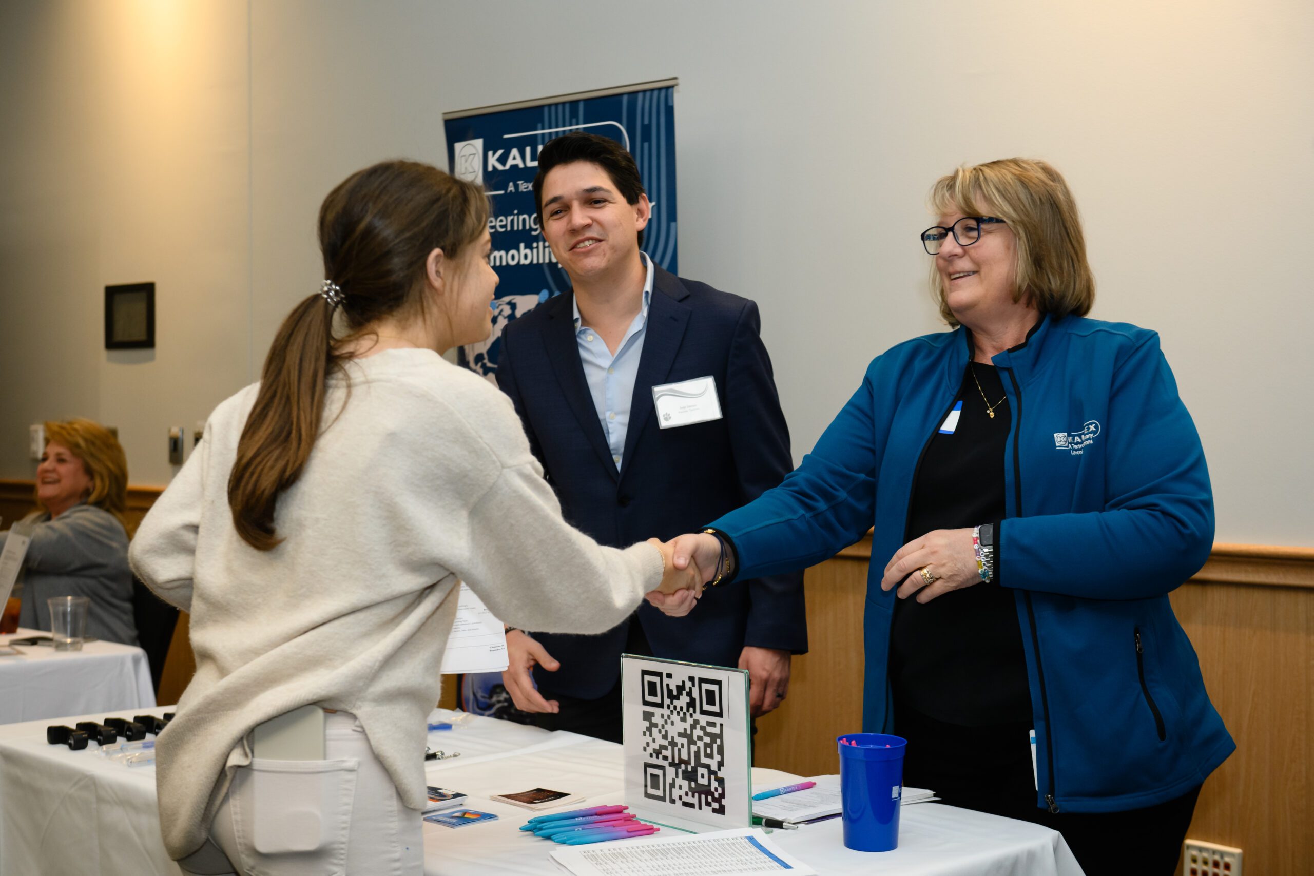 A student shakes the hand of a business person at a recent conference in the Hendrix Student Center.