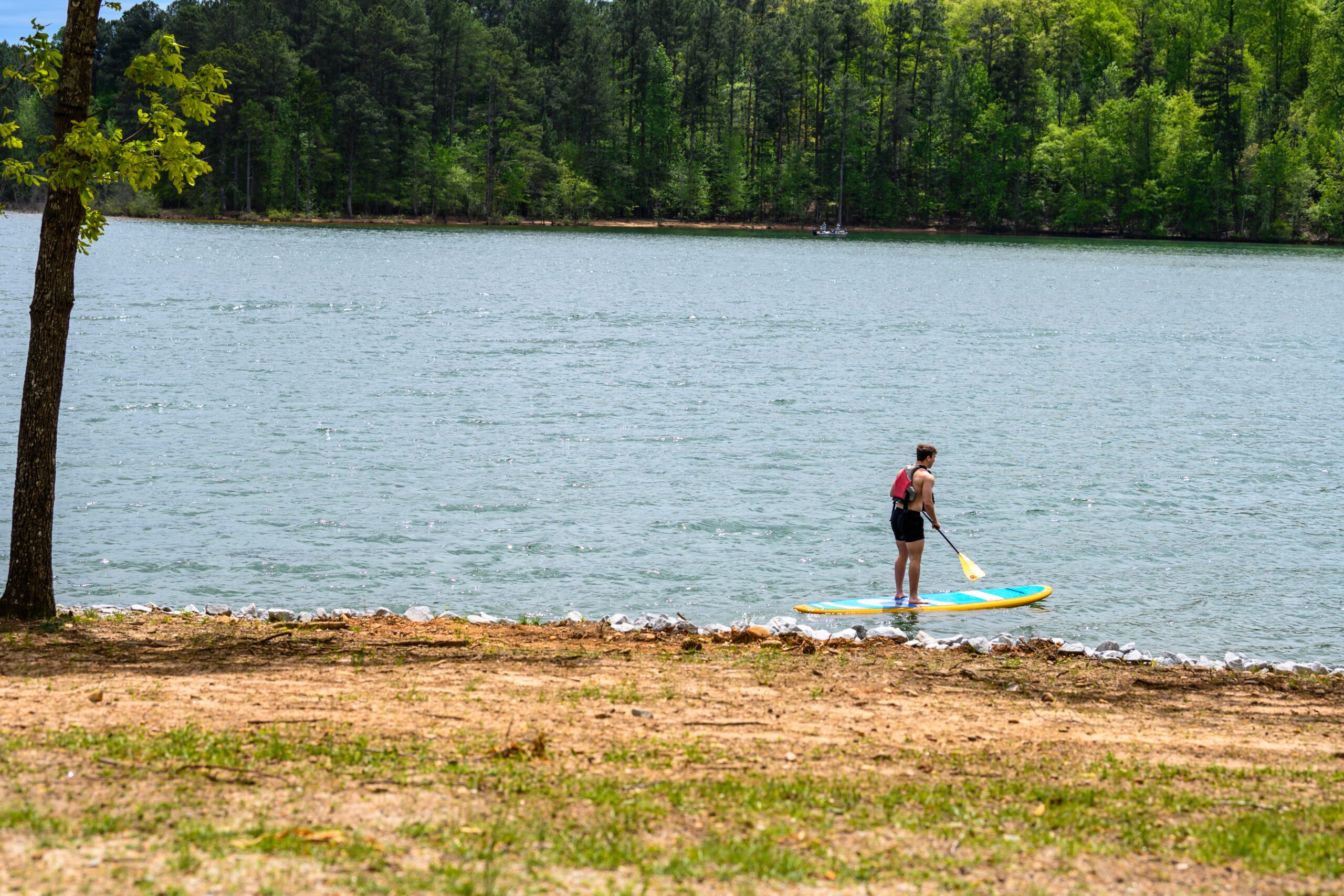 A student enjoys paddleboarding on Lake Hartwell
