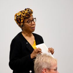 A woman standing giving a talk.