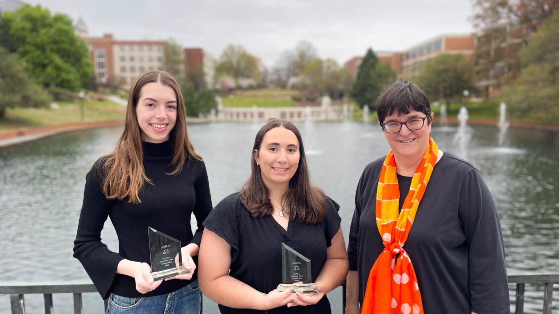 Caroline Morgan (left), Teresa Ribeiro (middle) and Cary Berkeley Kaye pose for a picture in front of the reflection pond on Clemson University's main campus. The weather is gloomy.