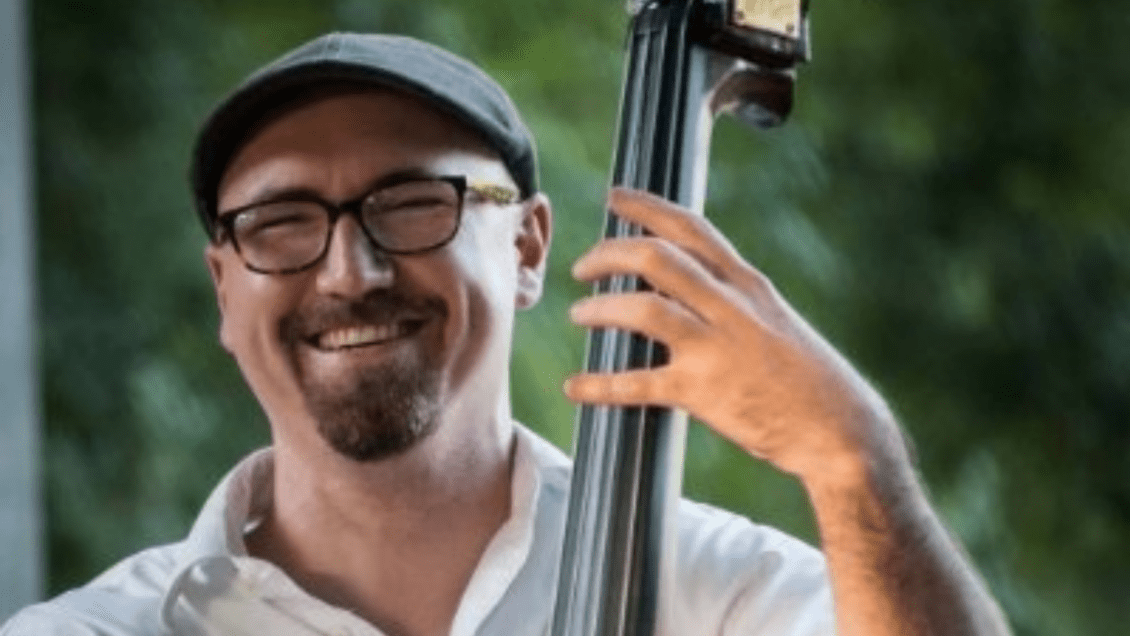 Michael Geib smiled at the camera as he plays his double bass.