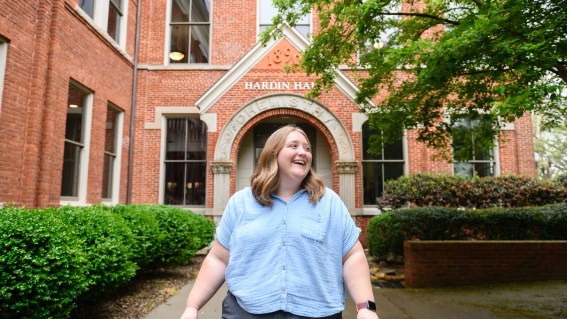 A college student smiles while she walks away from Hardin hall.