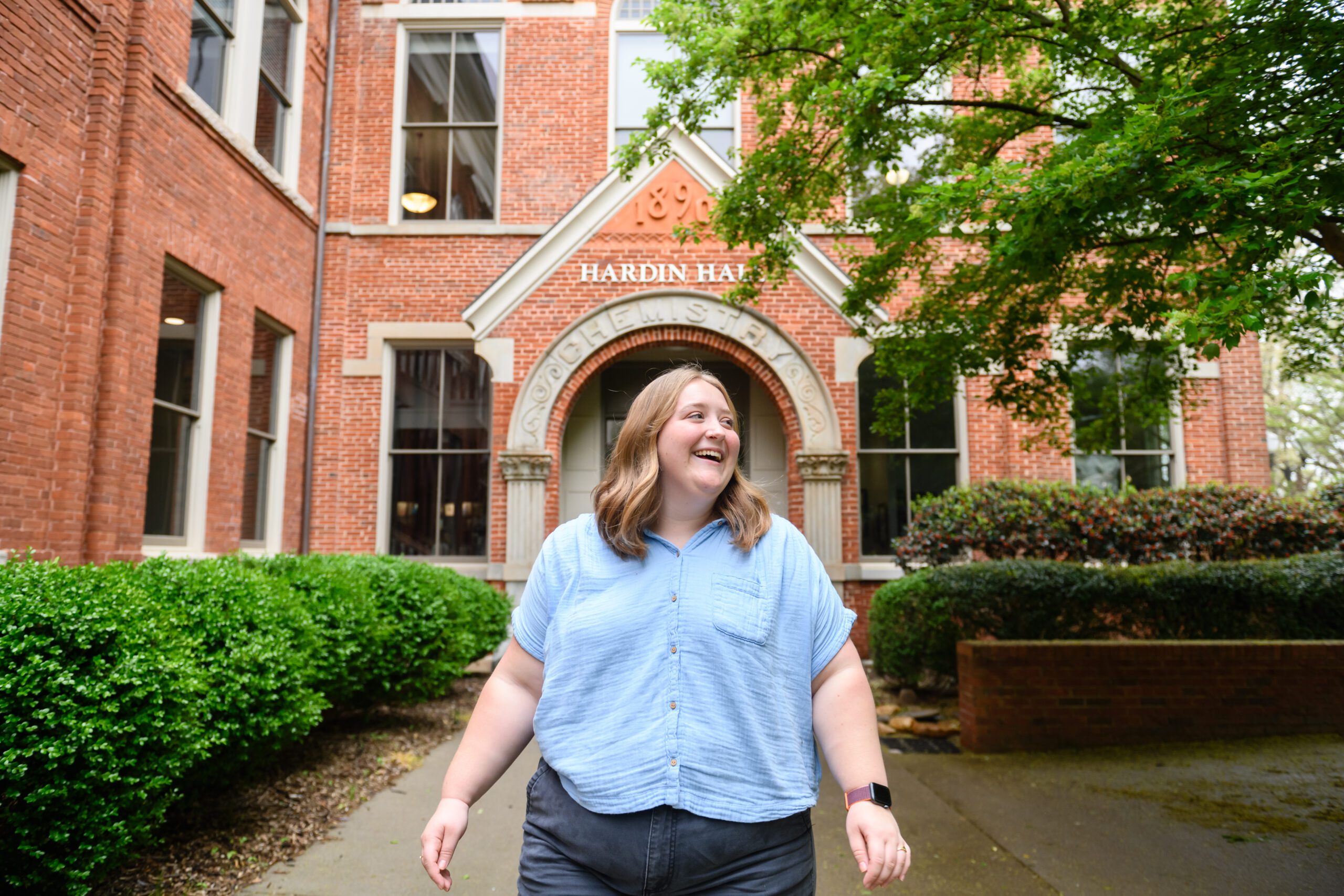 A college student smiles while she walks away from Hardin hall.