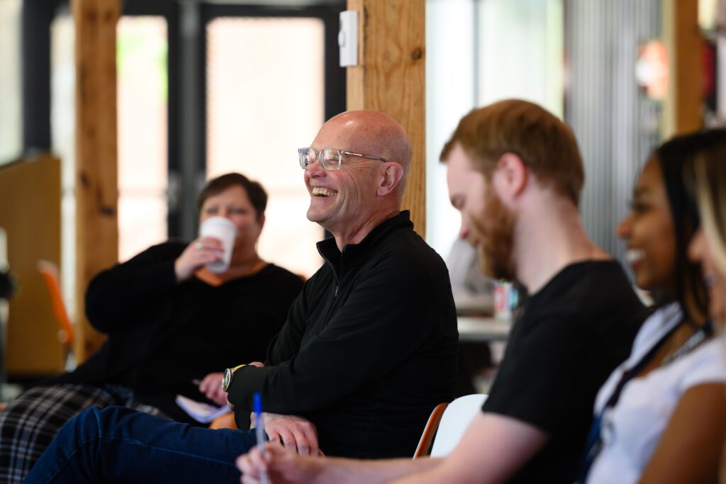 School of Architecture Associate Professor Timothy Brown flashes a smile and laugh while listening to Ron Rash speak.