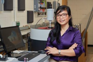 woman standing in front of machines in a science lab