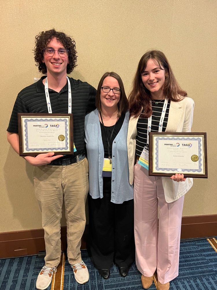 Amanda Bridges, associate graphic comm professor, poses for a picture with Griffin Sanders and Madison Wells at the TAGA competition.