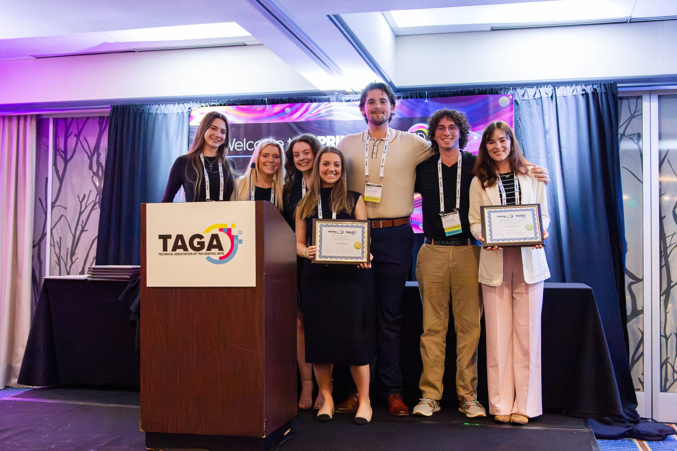 TAGA Student chapter stand on the stage as Attendee Choice Award Winners at the annual TAGA competition