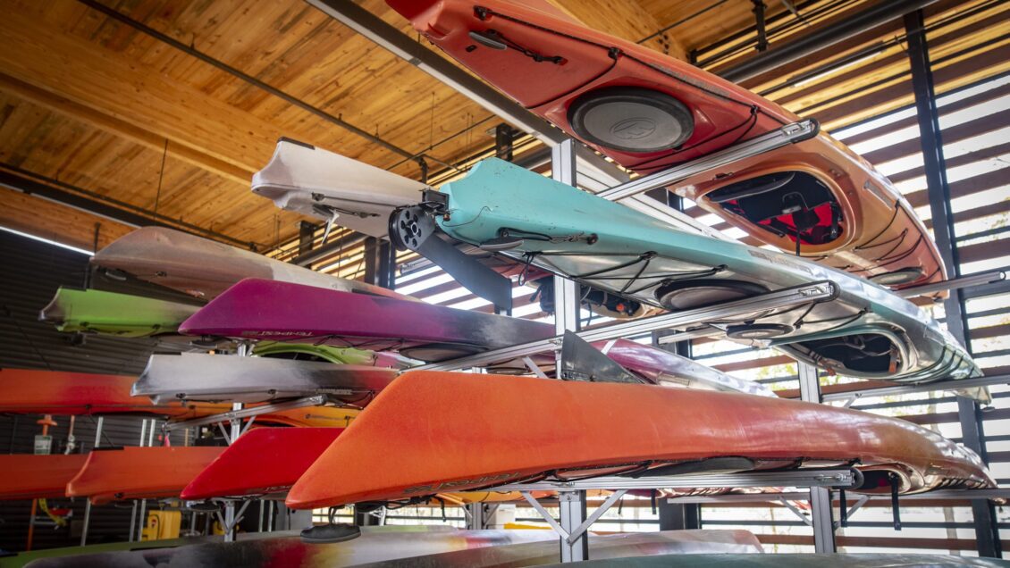 Various different colored kayaks on racks