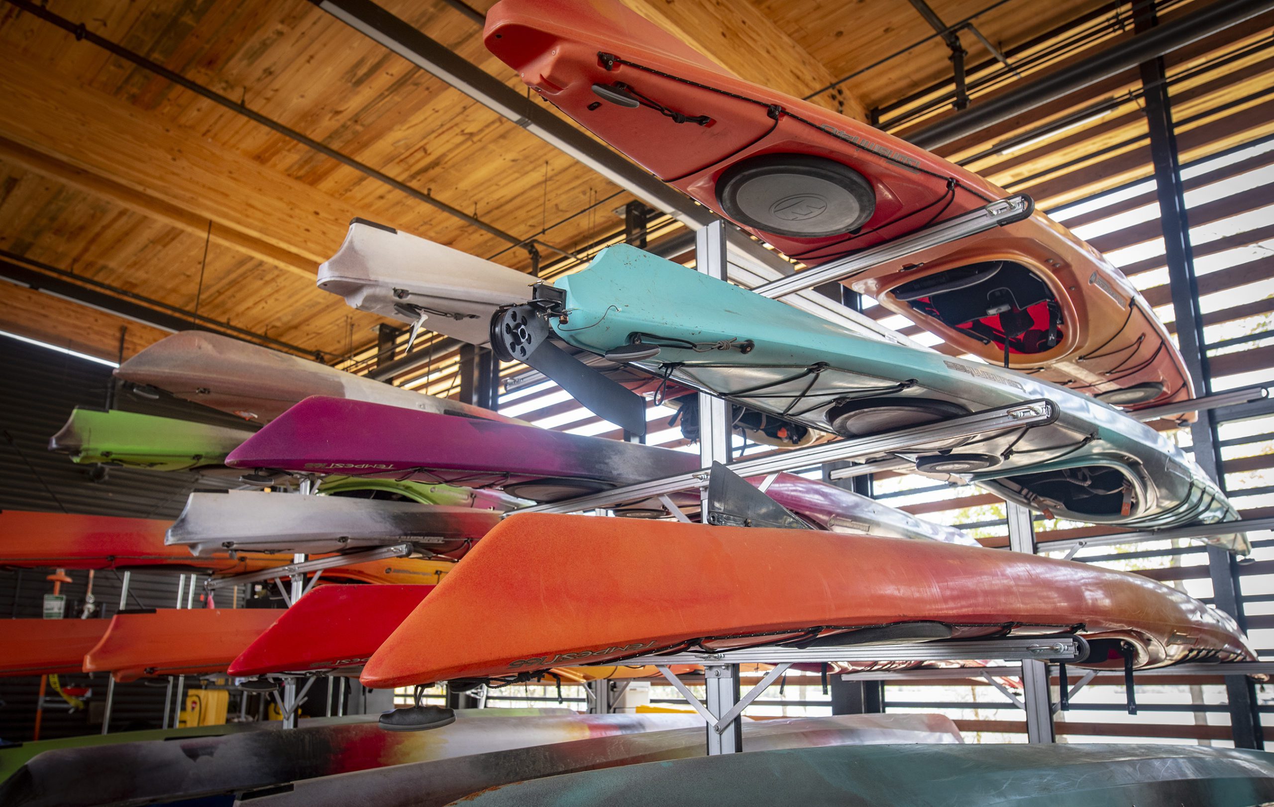 Various different colored kayaks on racks