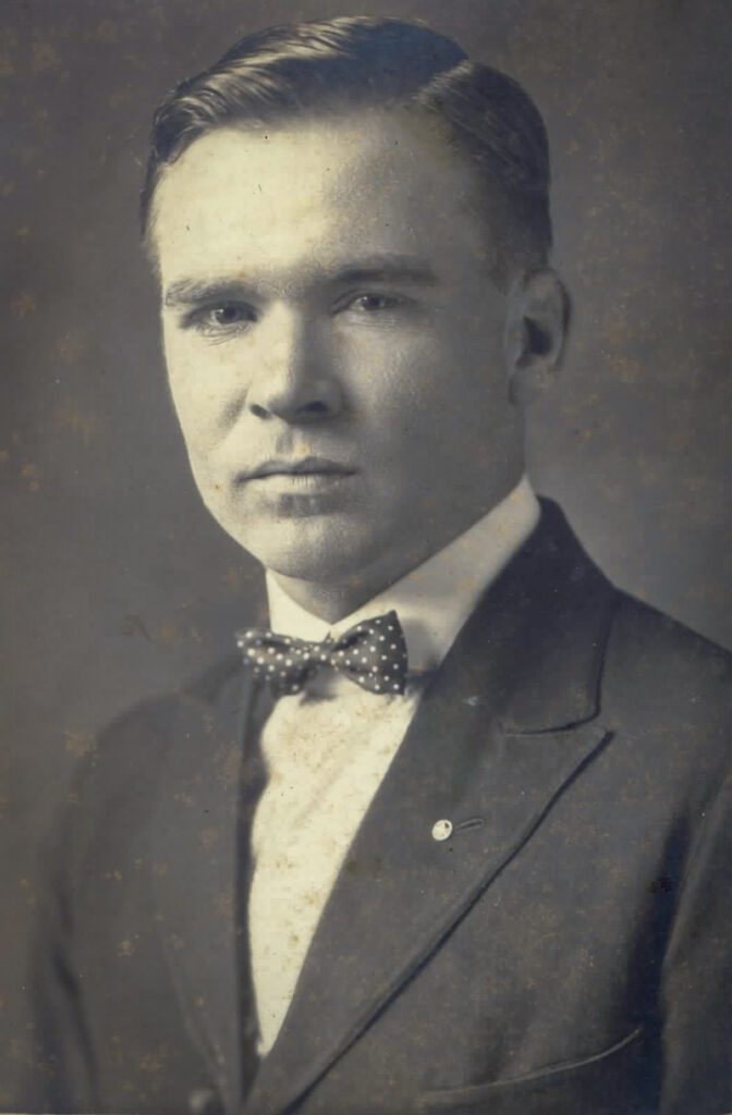 Black and white photo of a young man in jacket and bow tie