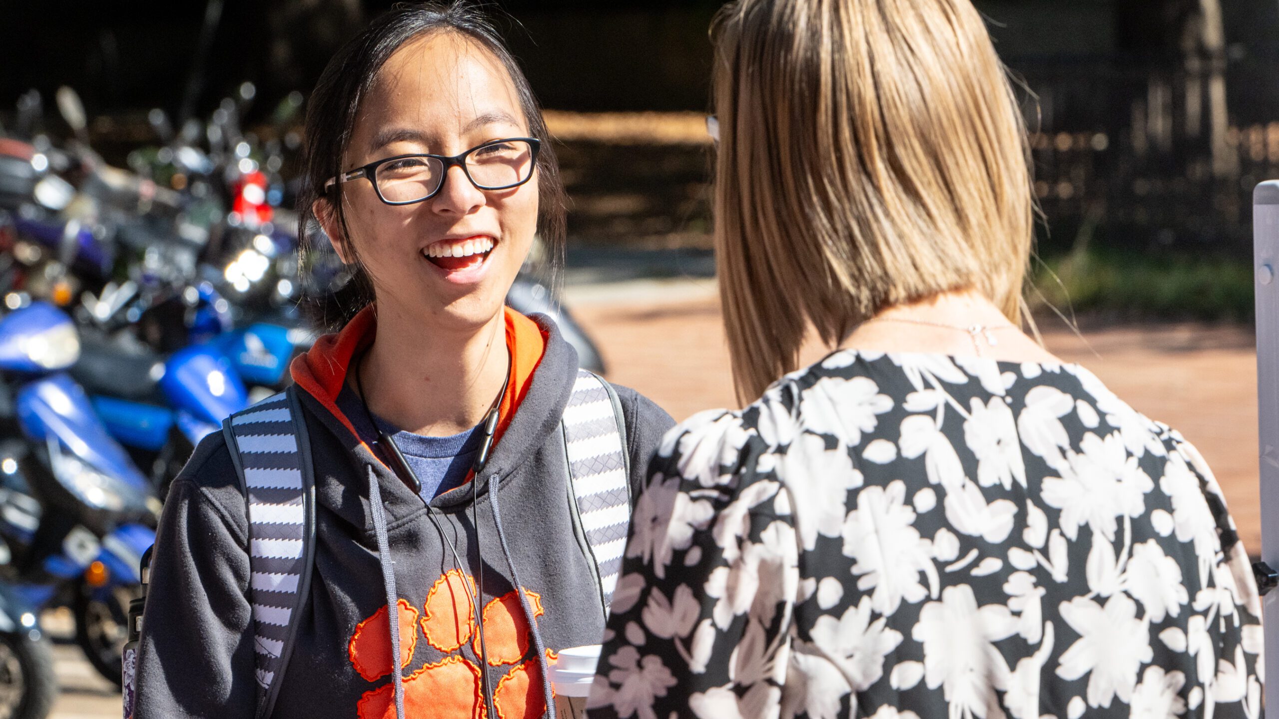 A student in a Clemson hoodie talks to a staff member.