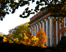 Sikes Hall surrounded by trees in the fall.