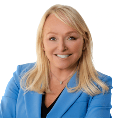 A chest and up photo of a smiling woman wearing a blazer and v-neck blouse.