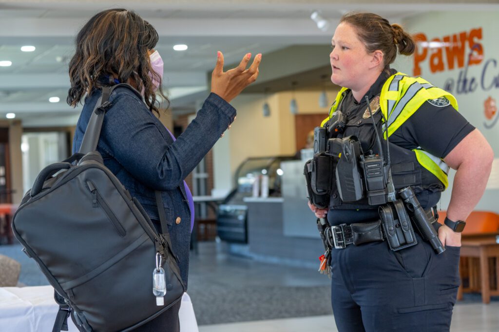 A woman with a COVID mask on talks to a female police oficer