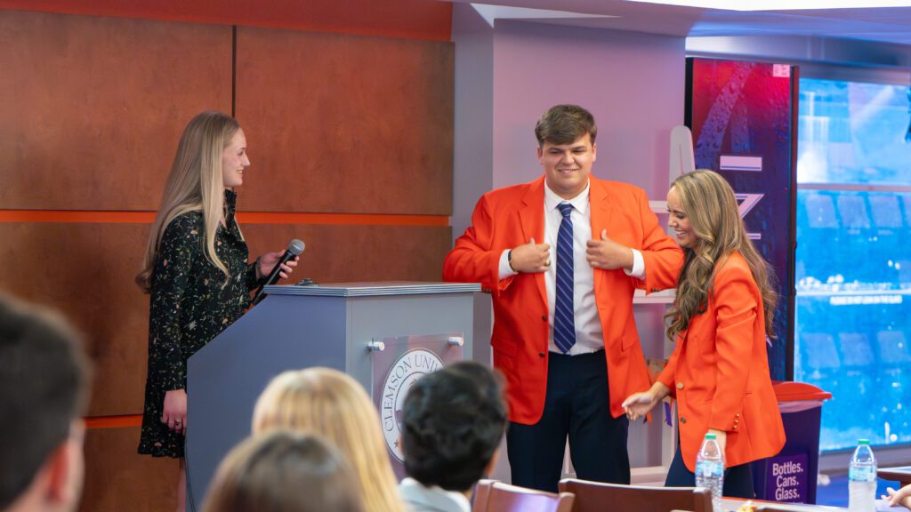 Zach Freeman receives the orange jacket from outgoing CUSG president Kellan Fenegan