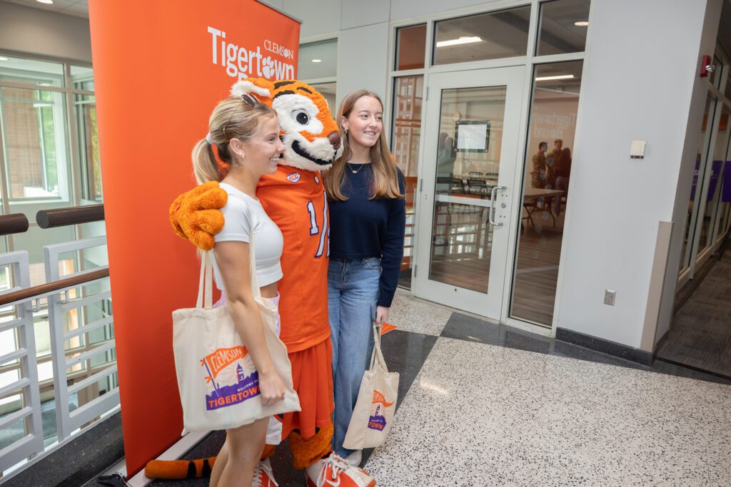 Students pose with Tiger Cub in front of an orange "Tigertown Bound" sign.