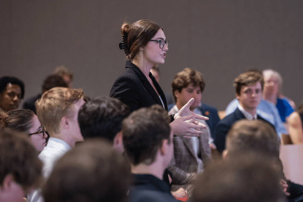 Management student, Isabella Bianchini, stands and asks a question to Bettinger.
