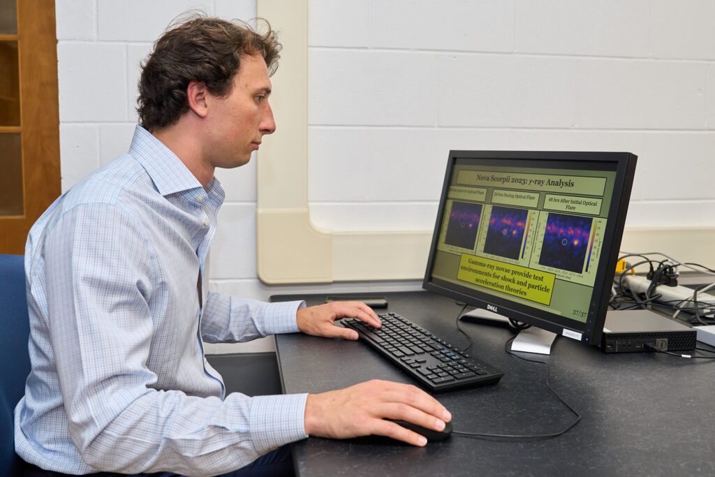 Man wearing a collared shirt works at a laptop computer
