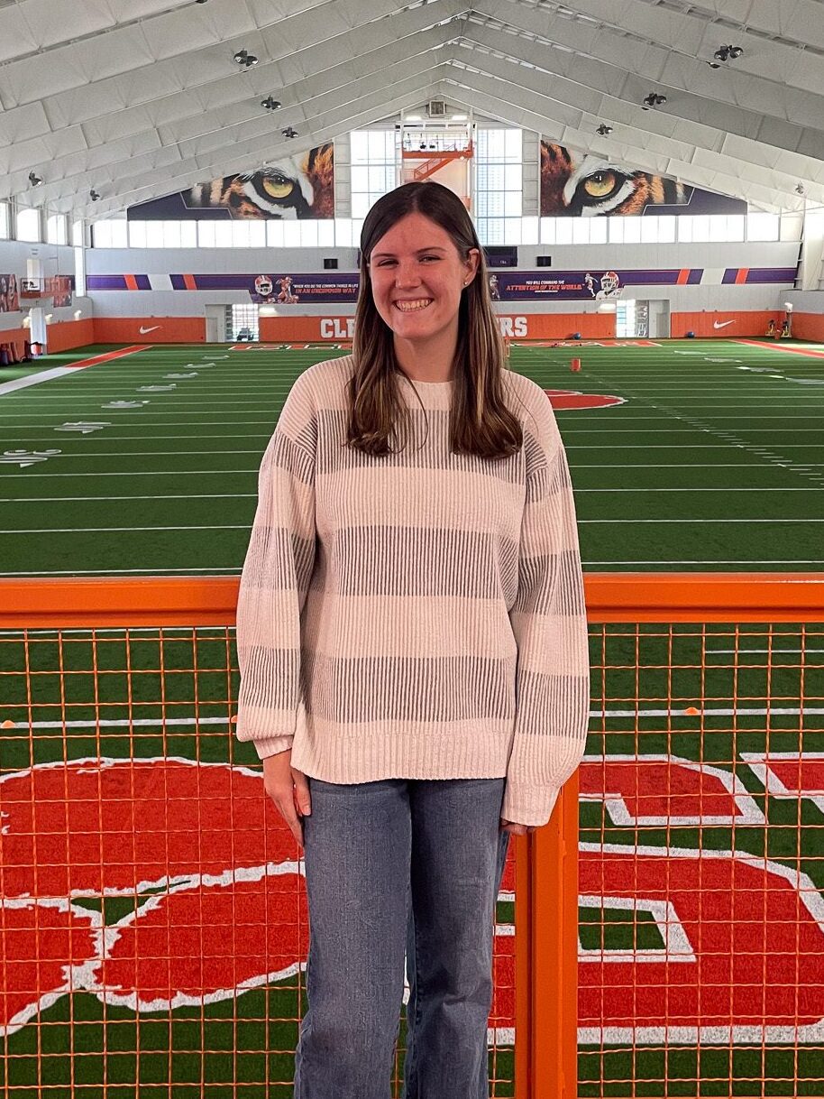 A woman standing in an interior sports installation, she is a scholar of Brooks