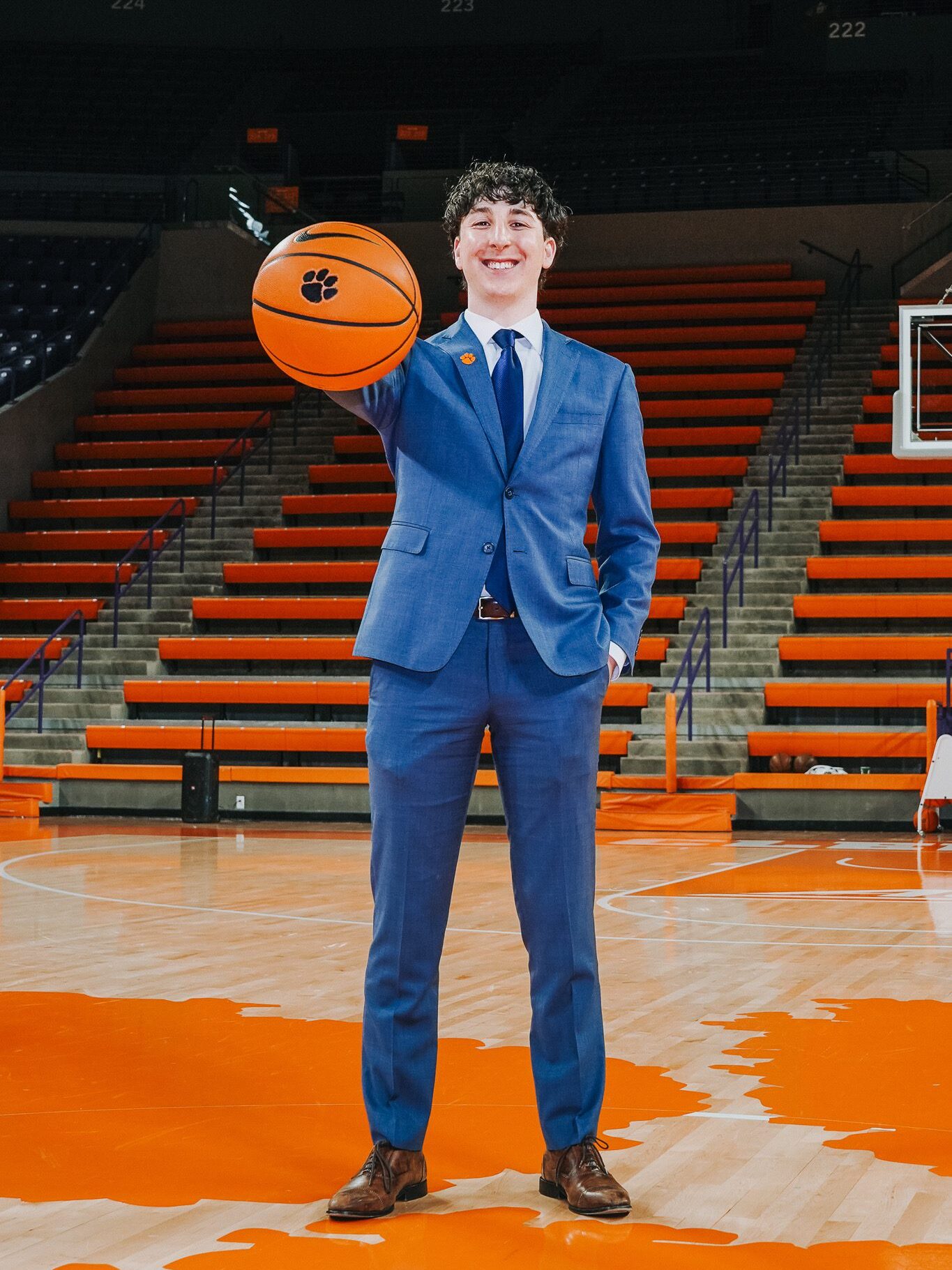 A man holding a Clemson basketball in the field, he is a Brooks scholarship holder