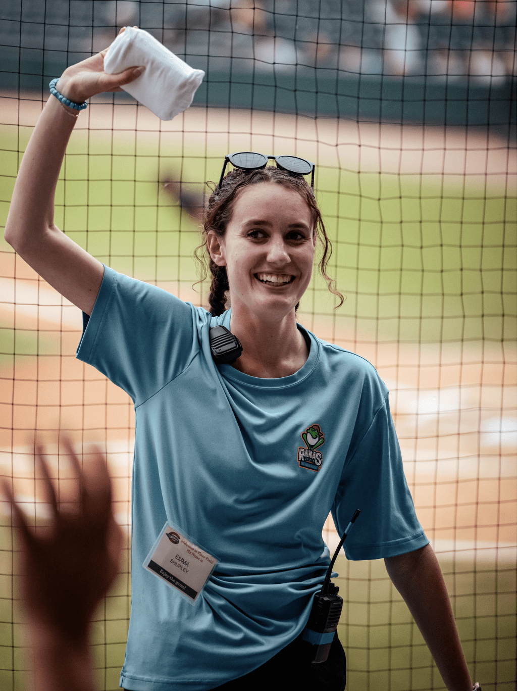 A woman holding an object above her head on a baseball field, she is a Brooks scholar