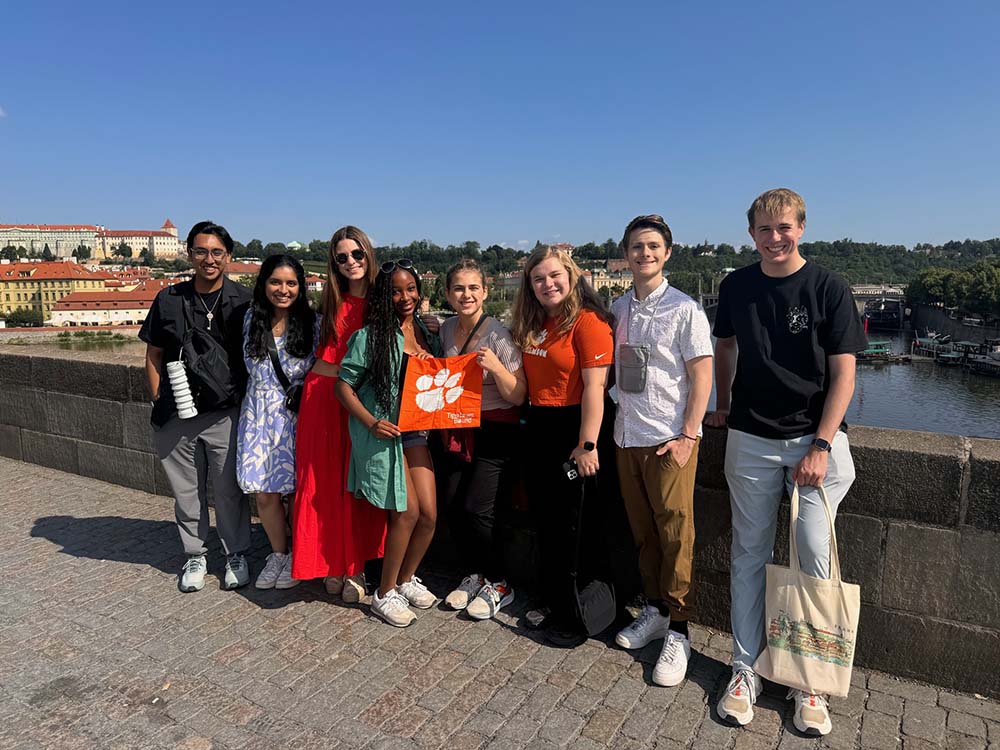 Briggs Murray standing on a bridge and posing with several of his National Scholars Program cohort (one of whom is holding a Tiger Rag) in May 2024.