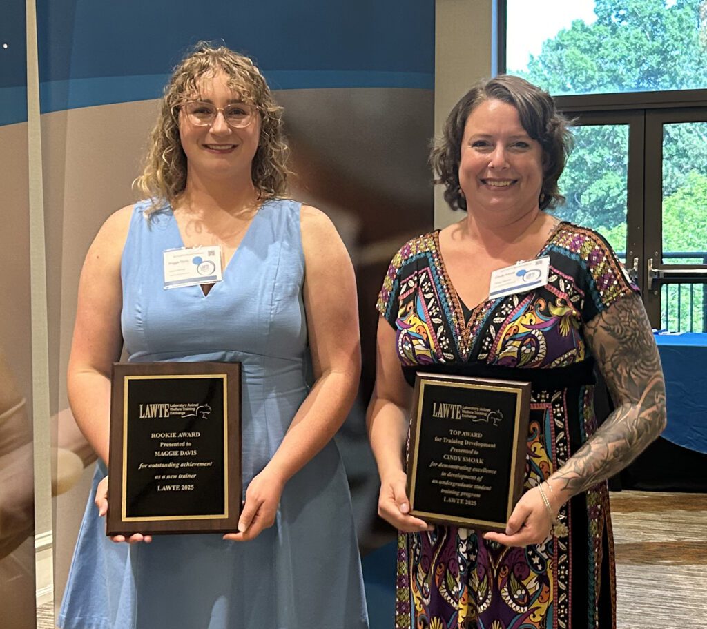Two women holding awards plaques