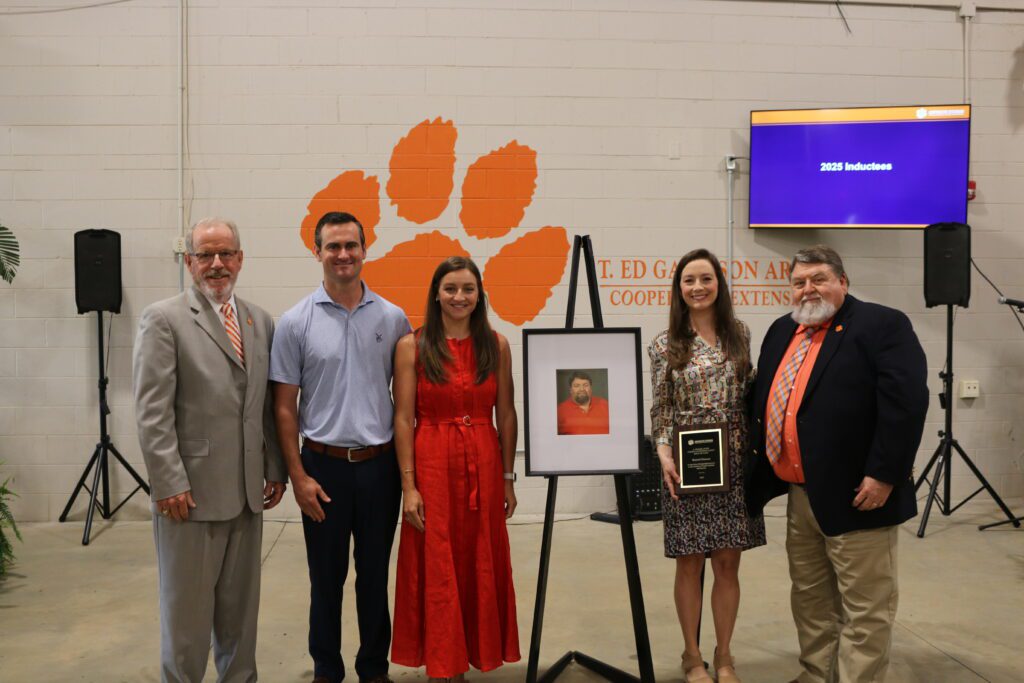 Russell Duncan is shown with his family and Clemson Extension Director Tom Dobbins after being inducted into the Lever Hall of Fame.